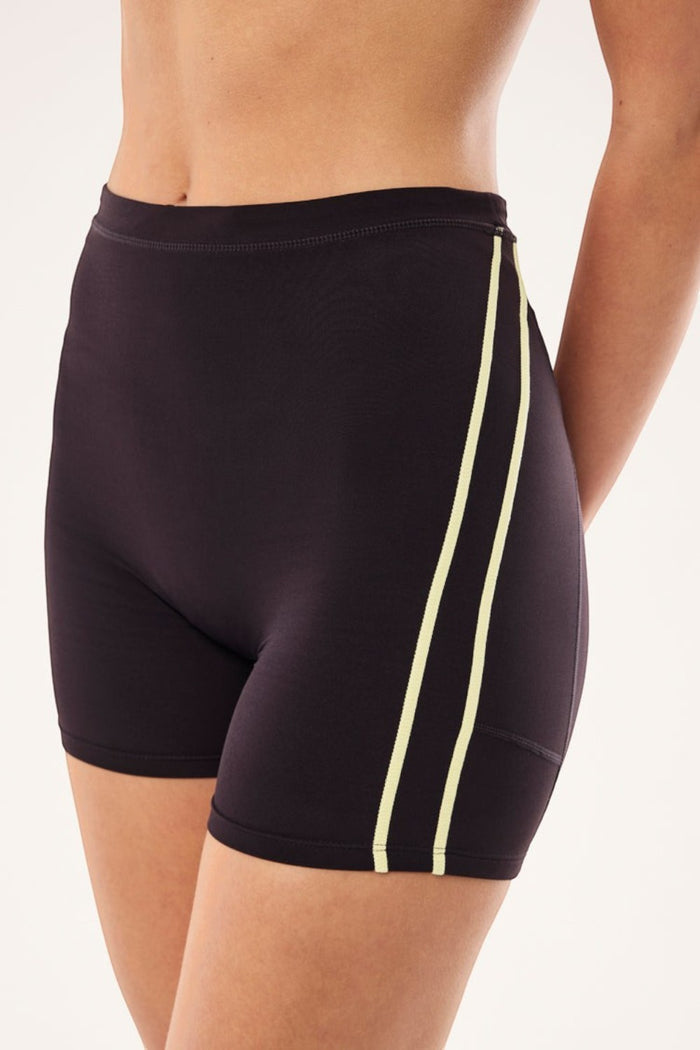 ELSHAM BOUTIQUE Cypher high-rise bike shorts in black bean with soft yellow contrast side stripes and side pockets.