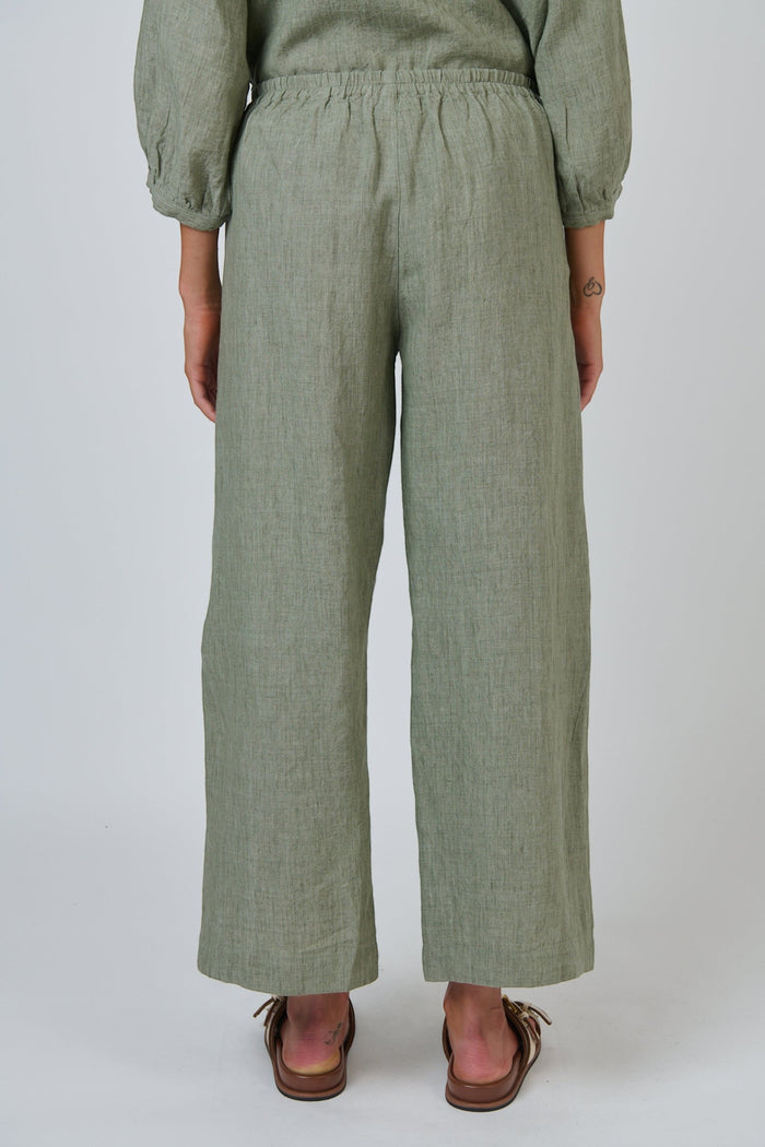 Back view of ELSHAM BOUTIQUE GA398 wide-leg linen trousers in artichoke green with a gathered back waistband.