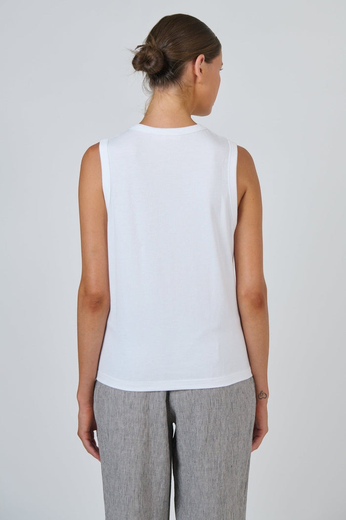 Back view of ELSHAM BOUTIQUE white cotton sleeveless muscle top with a round neckline on a model