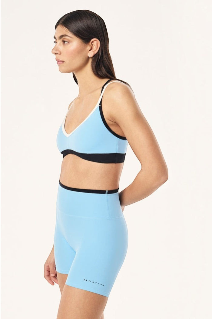 ELSHAM BOUTIQUE Paramount sports bra in Alaskan blue and black with V-neck and adjustable straps on a model