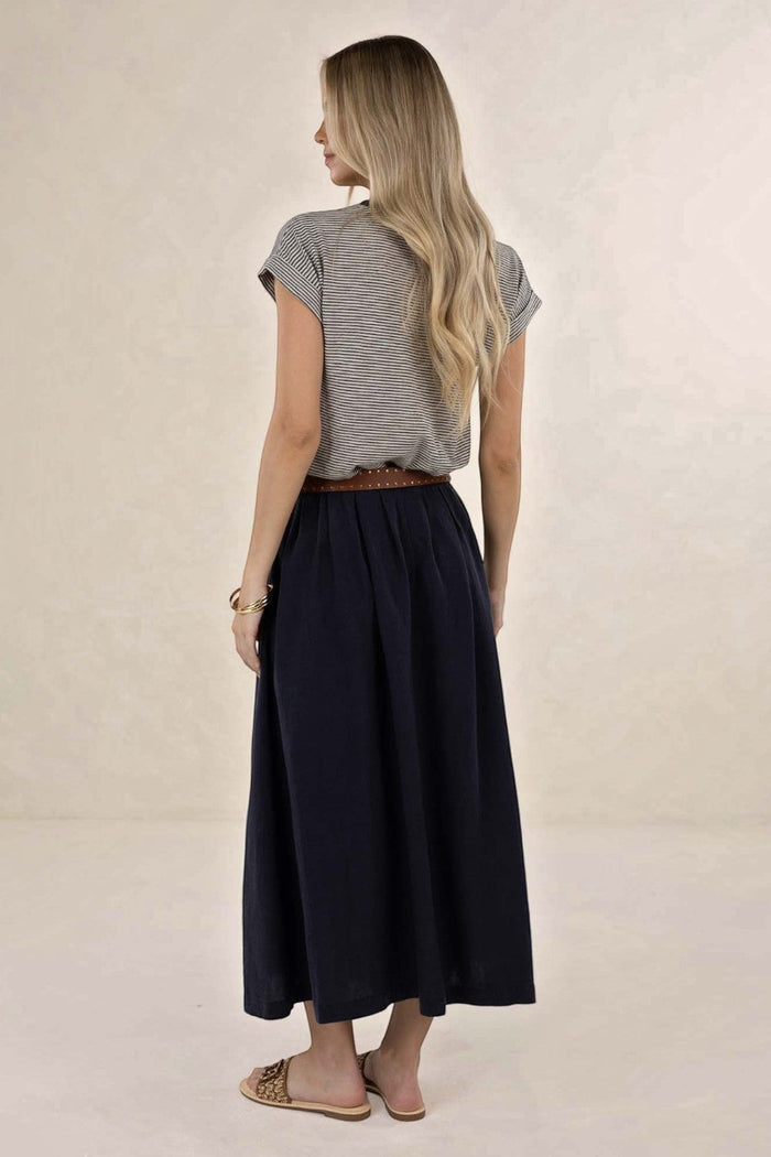 Back view of a woman wearing an ELSHAM BOUTIQUE navy linen-tencel midi skirt with an A-line silhouette and pockets.
