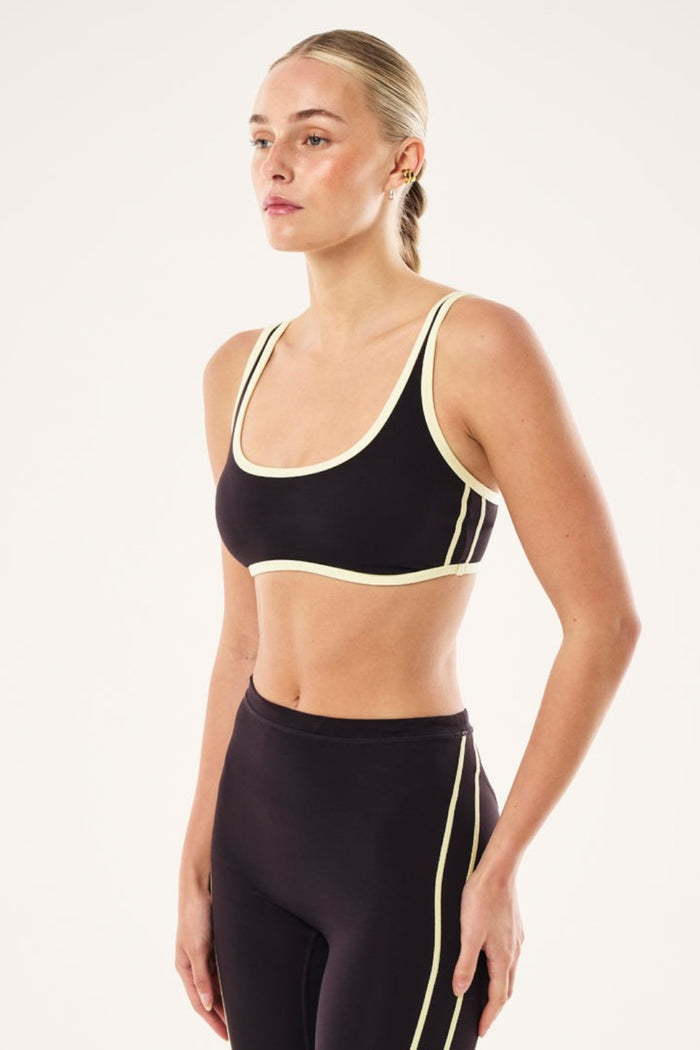 Model wearing ELSHAM BOUTIQUE black bean and soft yellow scoop neck sports bra with contrast binding