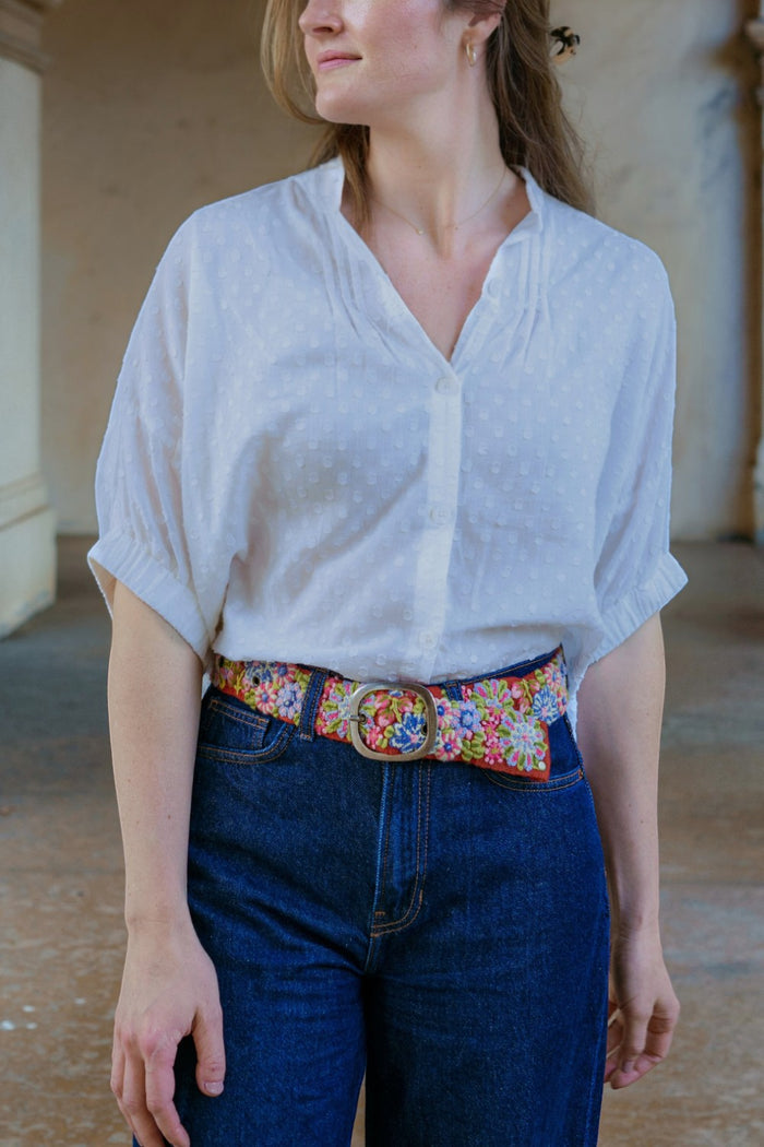 ELSHAM BOUTIQUE Teaberry wool belt with colorful floral embroidery and a metal buckle worn with jeans and a white top