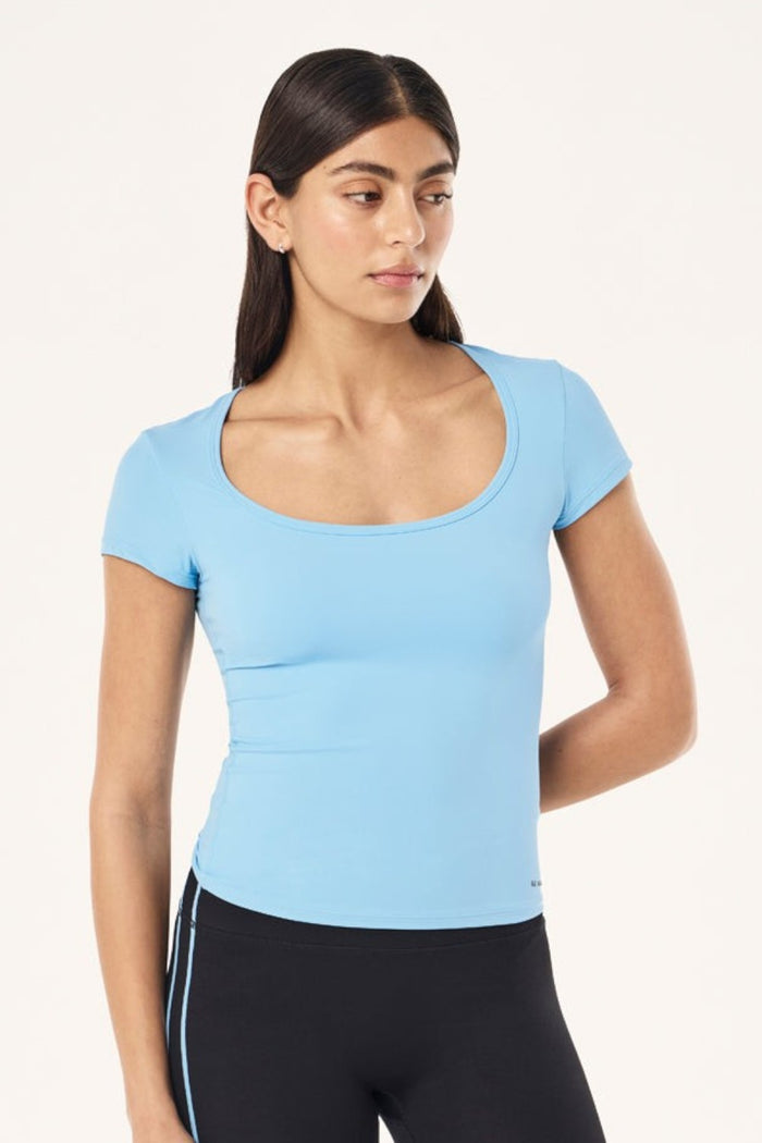 ELSHAM BOUTIQUE Alaskan Blue scoop neck short sleeve top in soft Body Luxe fabric worn by a model.